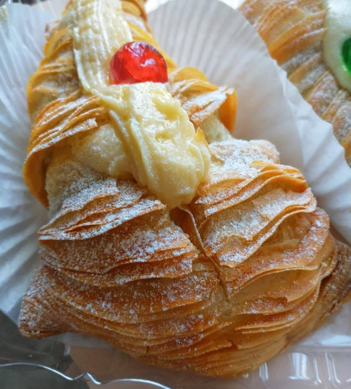 Fresh sfogliatelle filled with cream and topped with a cherry
